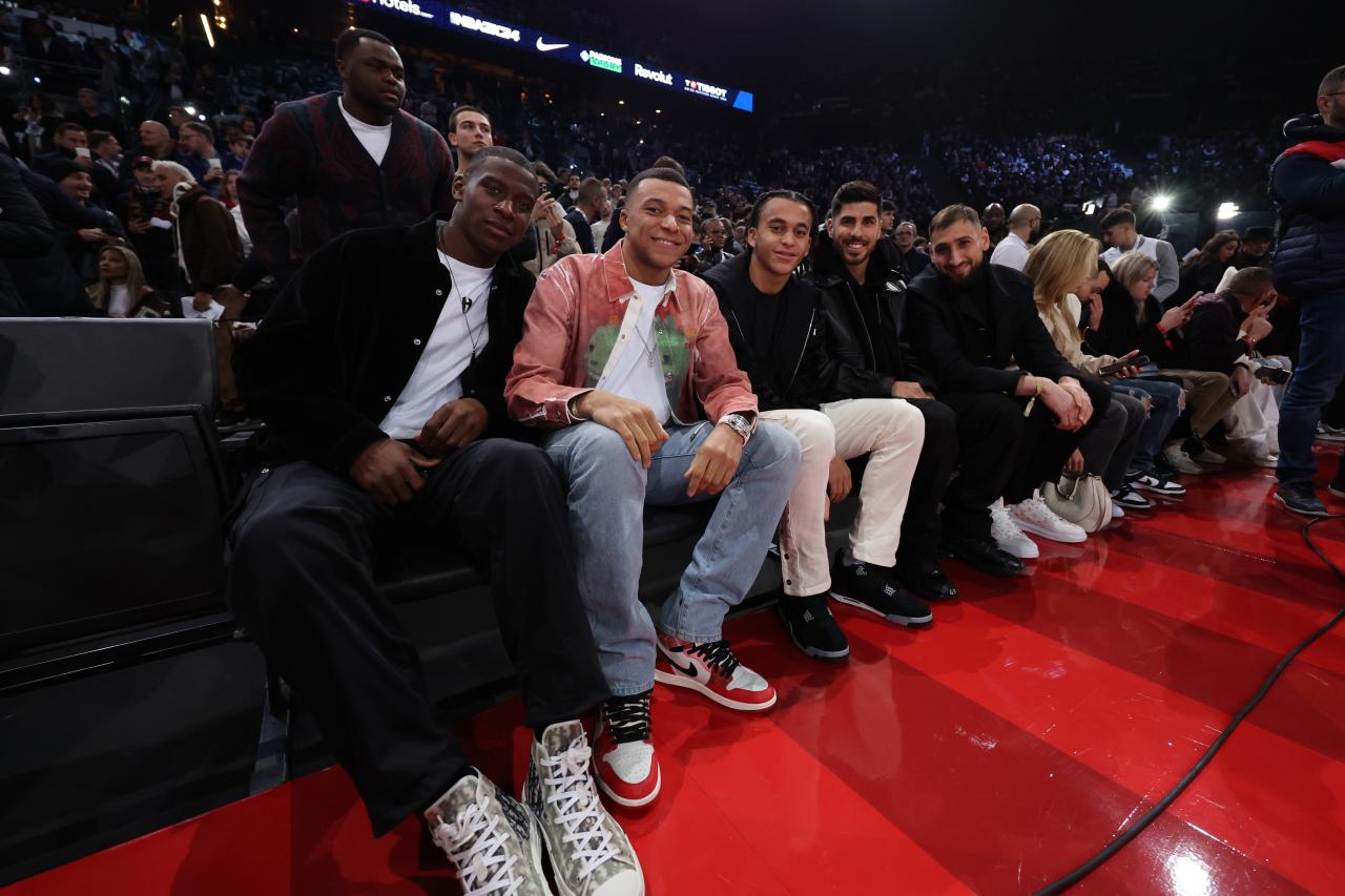 Kylian Mbappe attended the game flanked by PSG team-mates