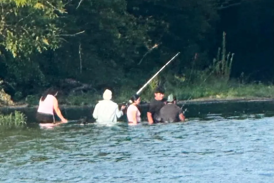 Group of people wading in the Scioto River while fishing.