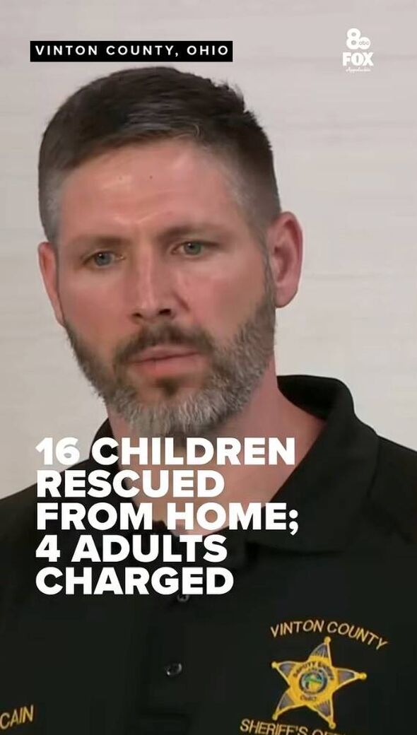 An individual with a short haircut and a beard is captured in a close-up shot, facing forward with a neutral expression. The bac