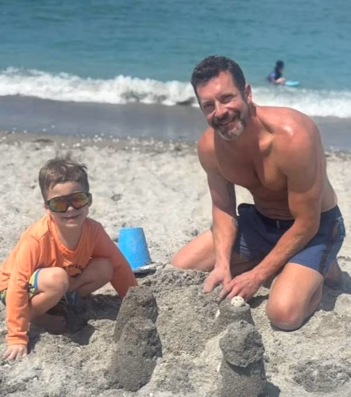 Kristopher Karolkiewicz on a beach with his son