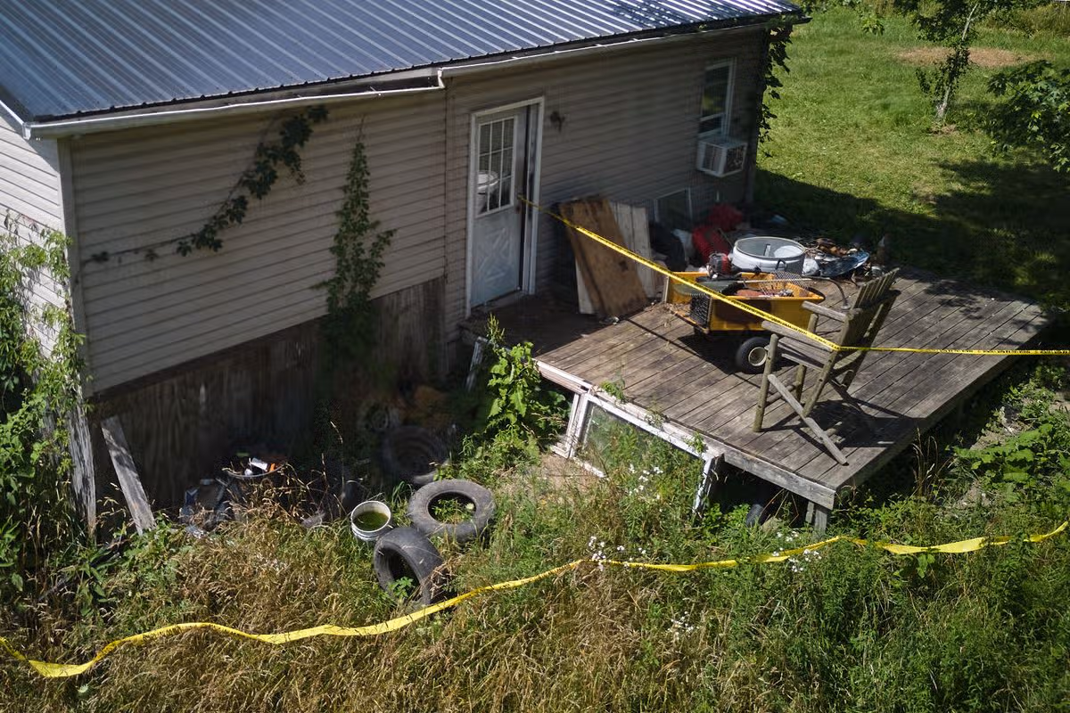 Police tape surrounds a home where authorities say they removed 16 children and arrested four adults in Hamden, Ohio, Wednesday, July 1, 2026.