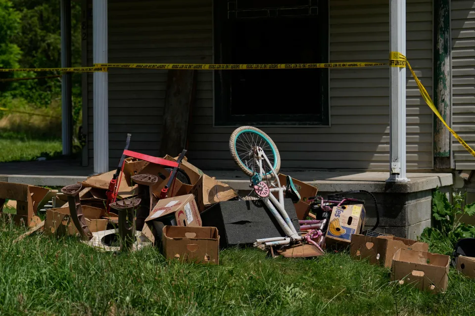 Police tape and debris are seen at a home where 16 children were removed.
