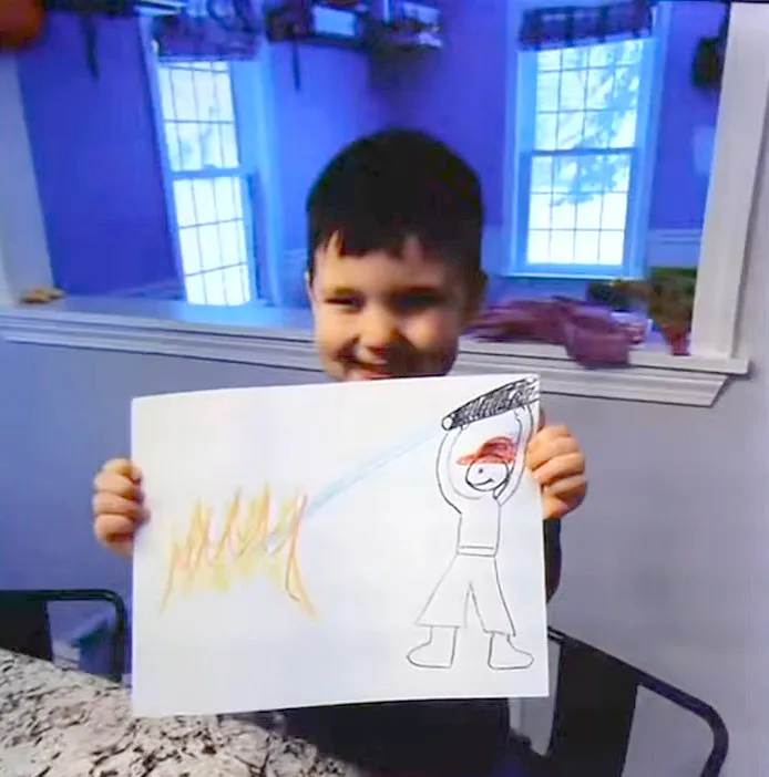 Dawson Clancy holding up a picture he drew