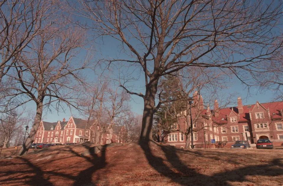 Overall view of McLean Hospital with leafless trees and a brick building.