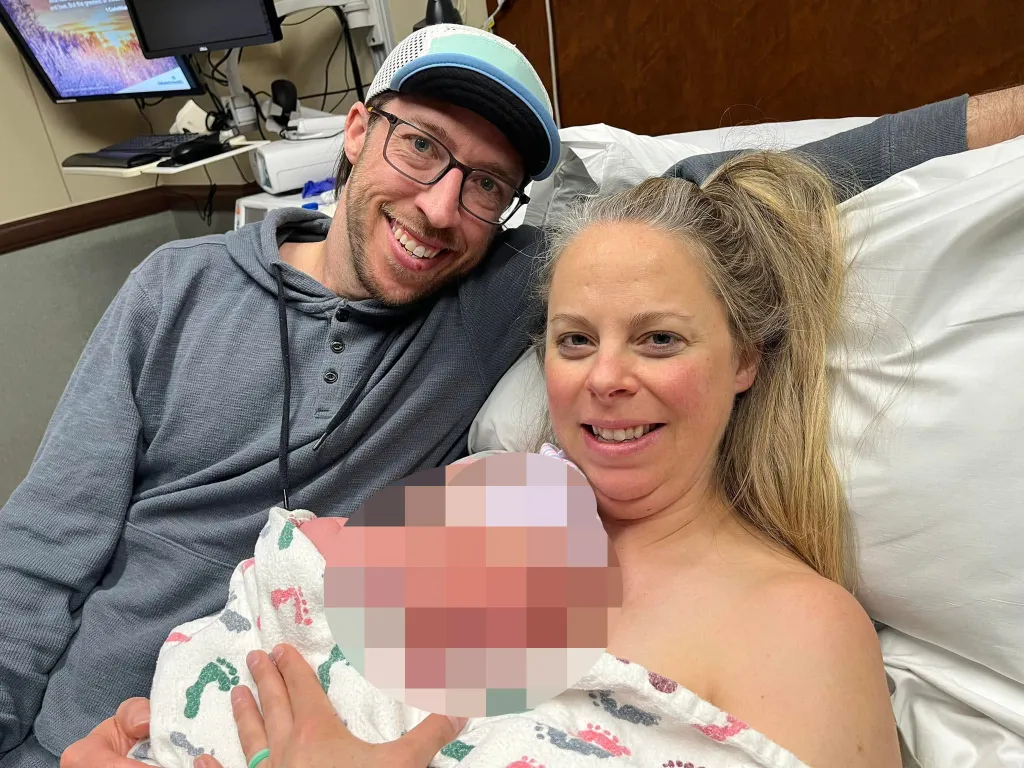 Patrick Theodore Barnett and Lindsey Barnett holding a newborn baby in a hospital bed.