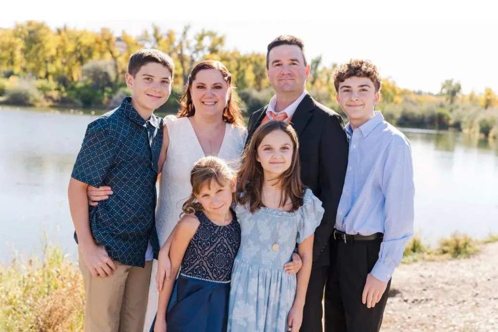 Megan Ghekiere, Owen, Charlotte, Landon, and other family members stand by a lake.