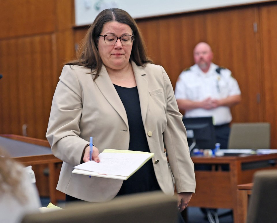 Prosecutor Jennifer Sprague holding documents in a courtroom.