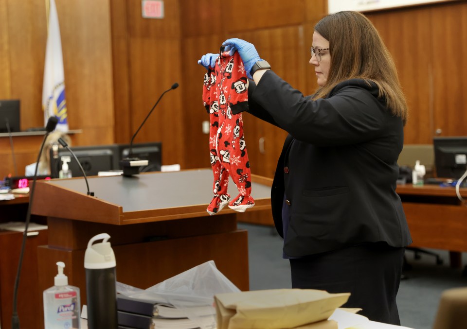 Assistant District Attorney Jennifer Sprague holding up red pajamas with Mickey Mouse print as evidence.