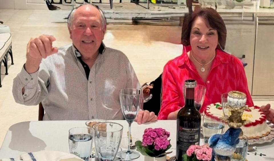 A man and a woman smiling at a dinner table.
