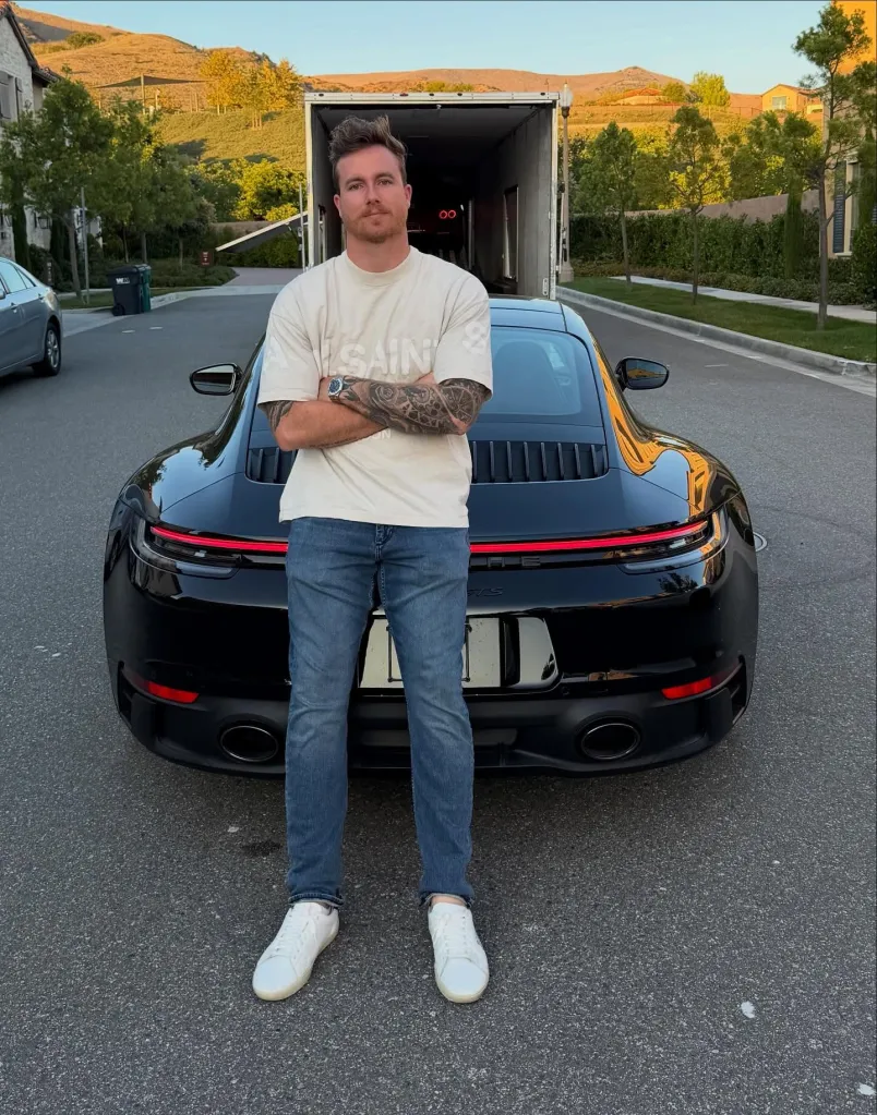 James Wehr stands in front of a black Porsche.