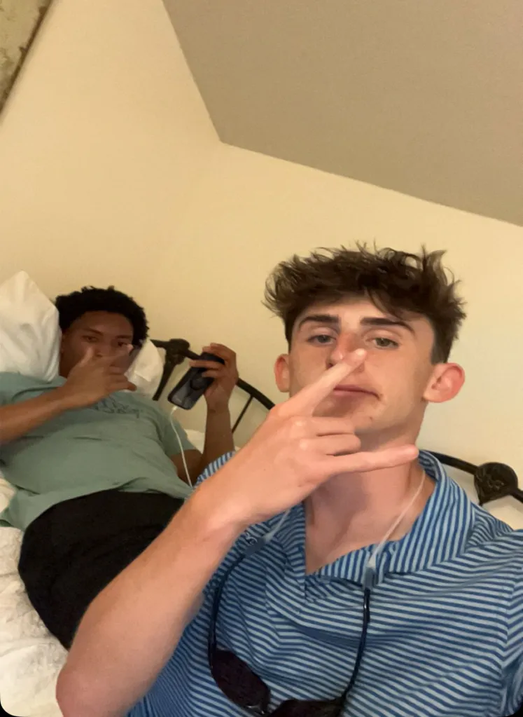 Two men posing for a selfie in a bedroom.
