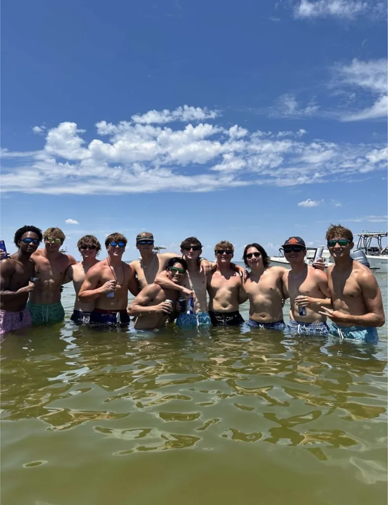 Group photo of Warren, Jax, Morgan, and Nolan in the water with others.