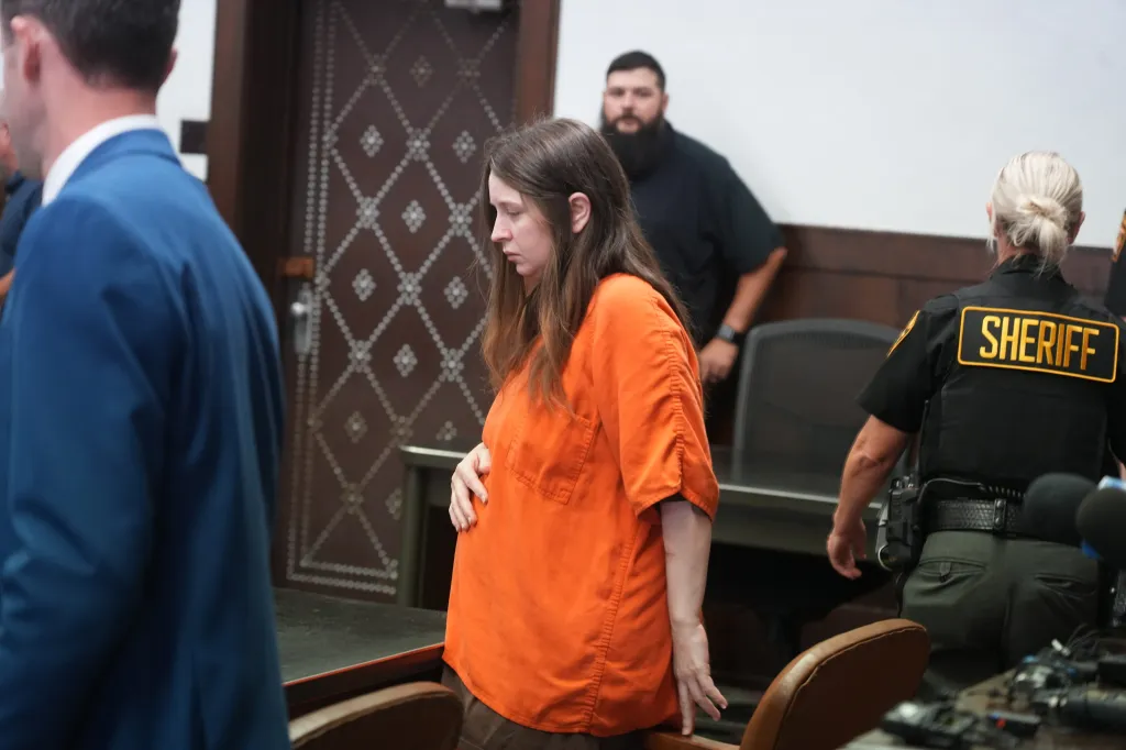 Elizabeth Siders appearing for arraignment in court, wearing an orange jumpsuit.