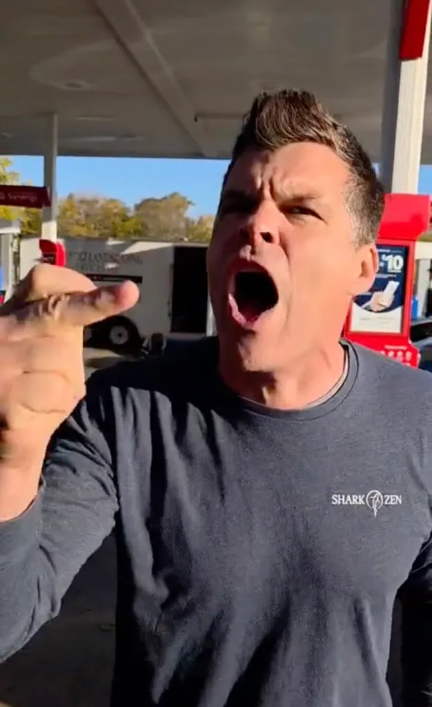 Matthew Arndt yelling and making an obscene gesture.