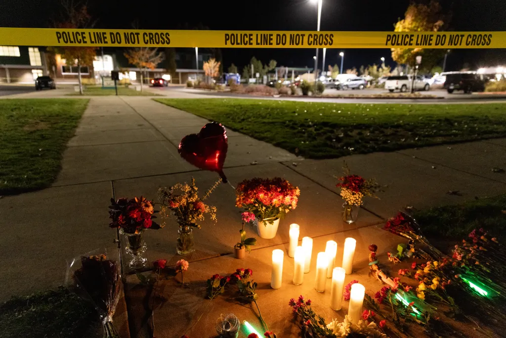 Candles and flowers are placed at a makeshift memorial outside the Silver Rail Elementary School.