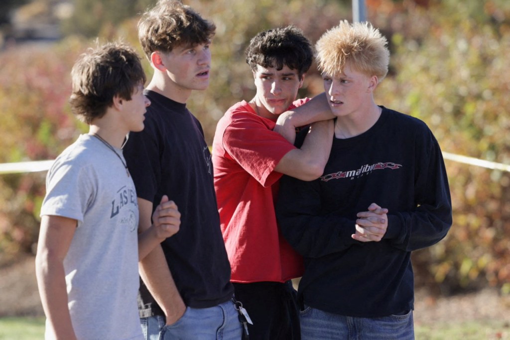 Four neighborhood students stand together on a sidewalk following a shooting at Silver Rail Elementary School in Bend, Oregon.