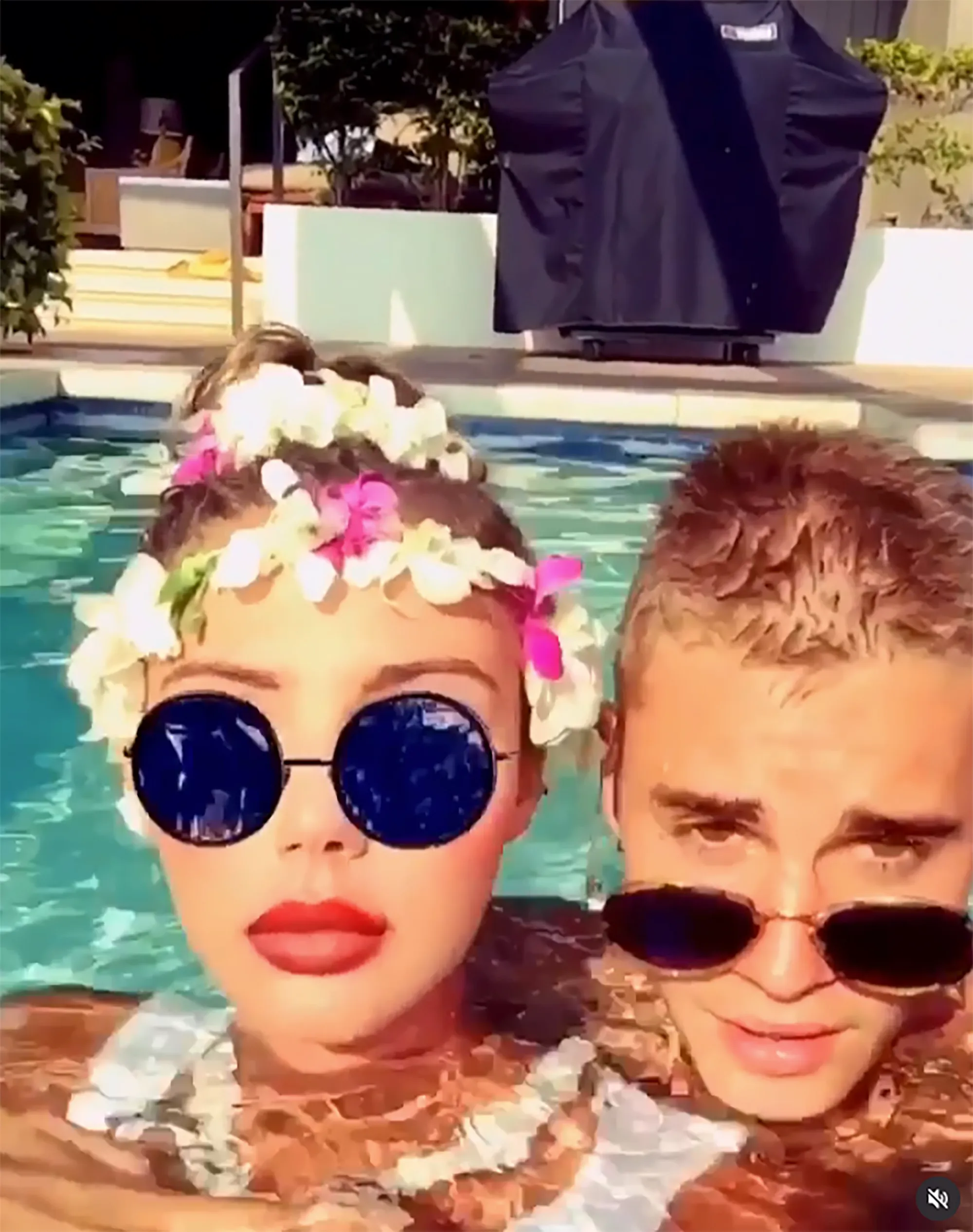 Model Sahara Ray and Justin Bieber posing together in a swimming pool.