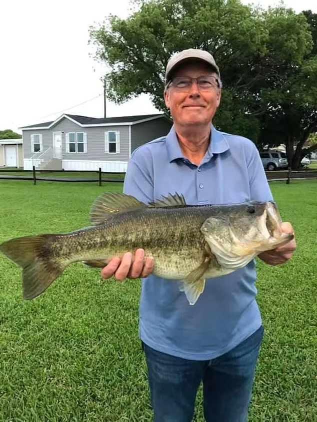 Steven Hamilton smiling while holding a large fish he caught.