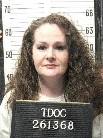 Booking photograph of Christa Pike with a height chart in the background.