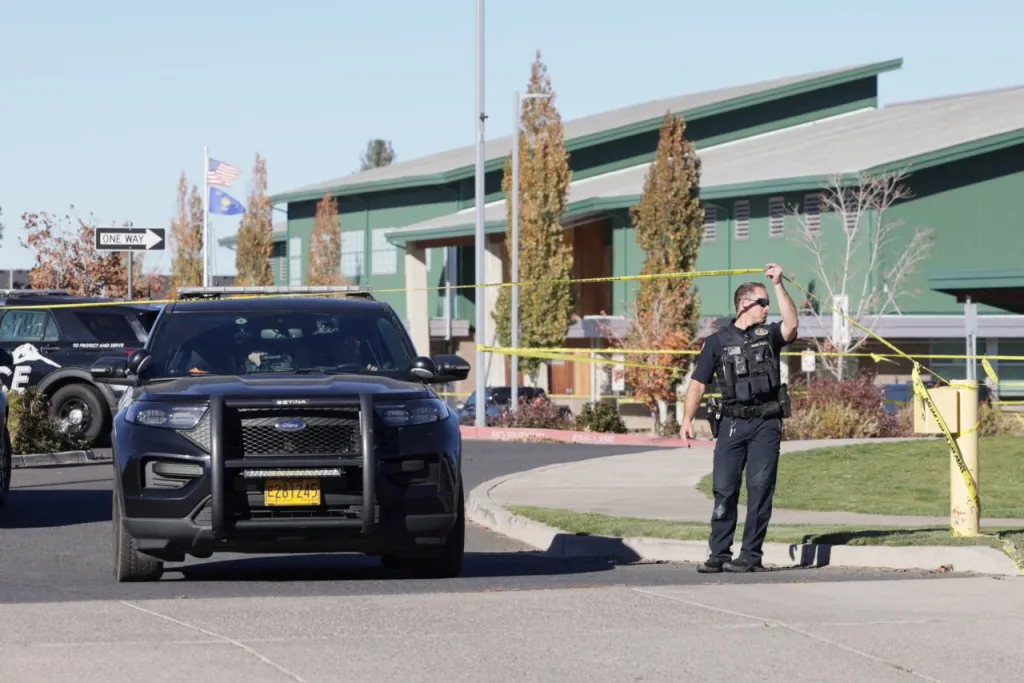 An emergency worker holds up police tape at Silver Rail Elementary School in Bend, Oregon.