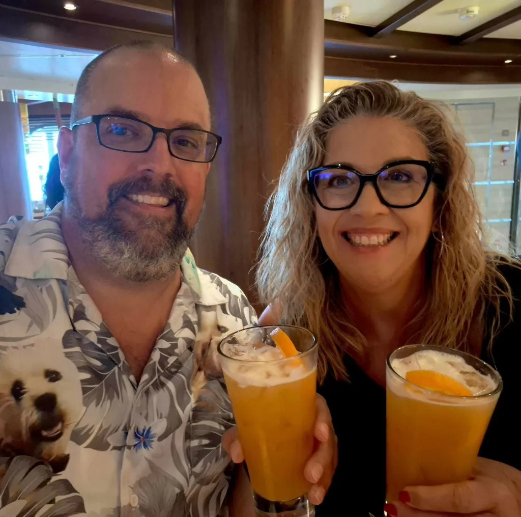 Becky Pendleton Drury and a man smiling while holding drinks in glasses.