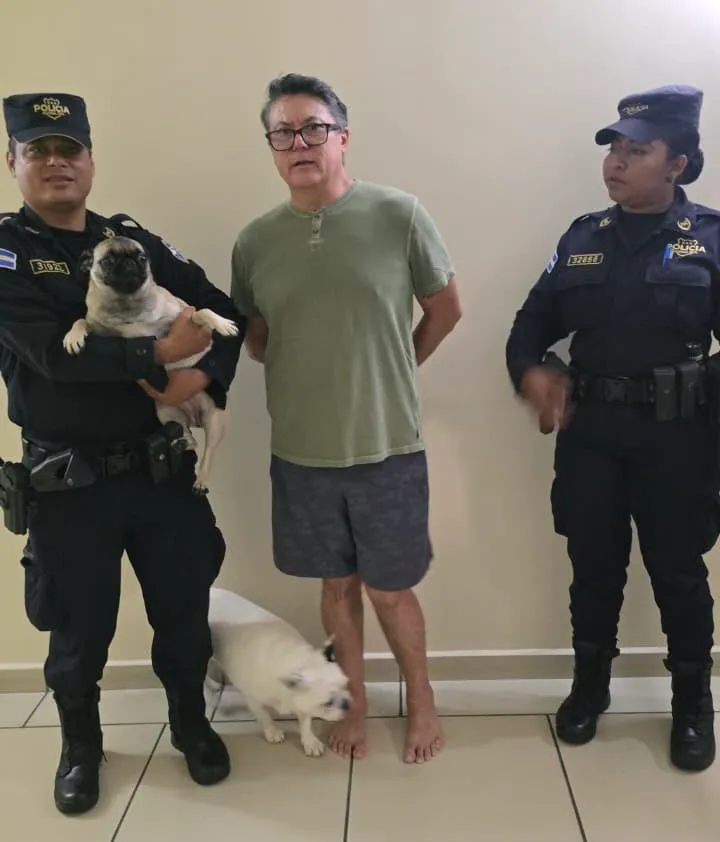 Héctor Alejandro Rosales Bonilla flanked by two police officers, one of whom is holding a pug, following his apprehension for animal cruelty.