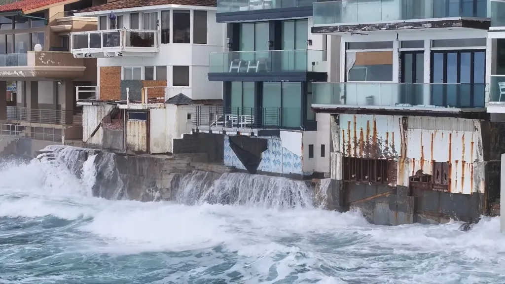 High tides crashing against coastal homes and seawalls.
