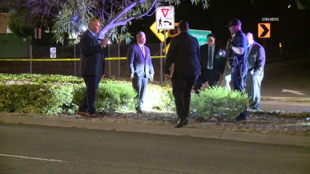 Police officers and investigators at a crime scene where a vehicle struck multiple cyclists.
