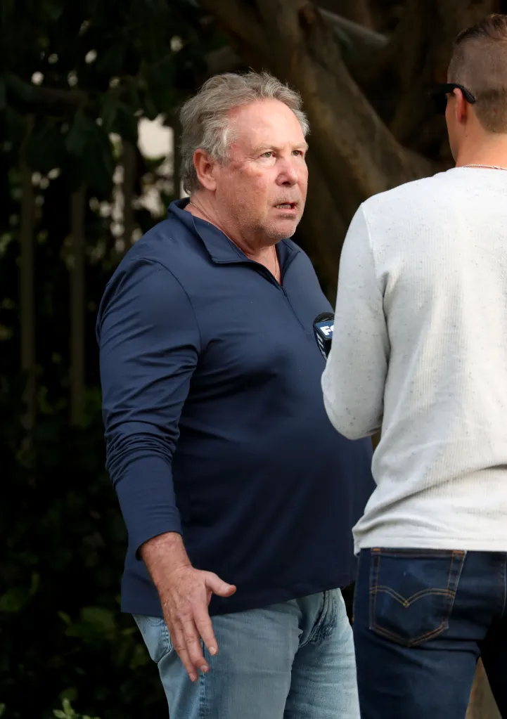 Stephen Cloobeck speaks to a news crew outside his mansion in California.