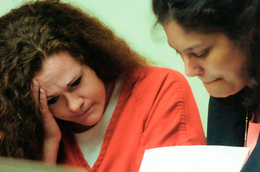 Christa Gail Pike and defense attorney Catherine Brockenborough look over paperwork during a hearing.