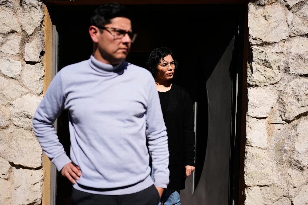 Fernanda Aguero and Gustavo Oviedo stand outside their home in Carlos Paz, Argentina.