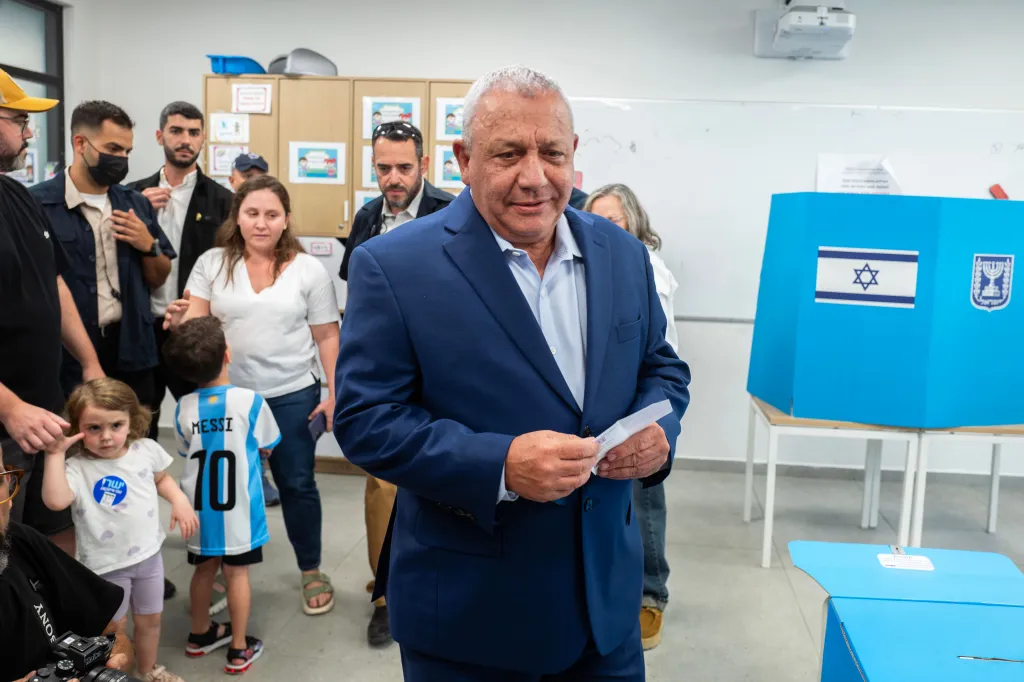 Gadi Eisenkot holding his ballot while waiting to vote at a polling station.