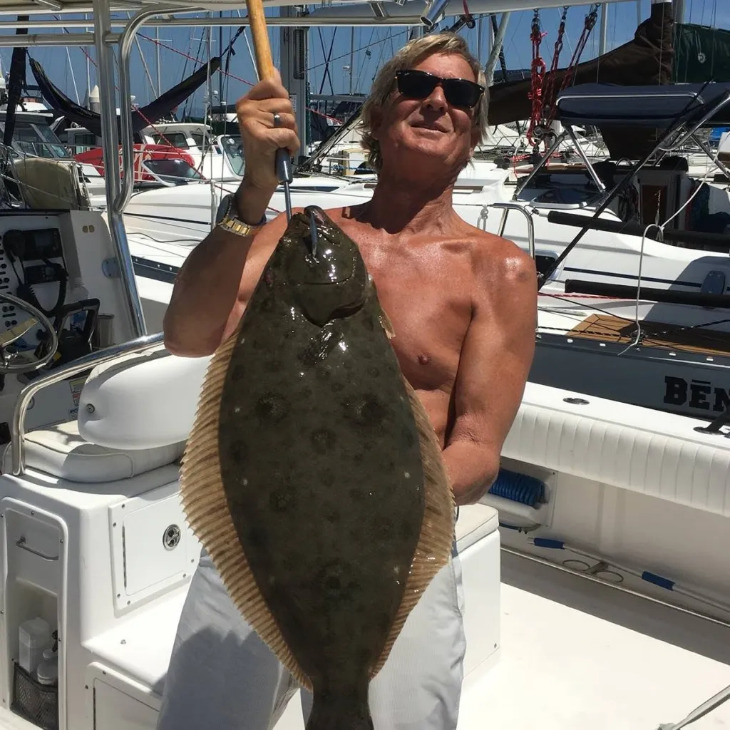 Marc Walter Fleming holding a large fish on a boat.